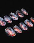 Handmade press-on nails with smoky gray, black, and copper metallic fan patterns arranged on a black background.