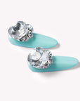 Closeup of Aqua Bijou press-on nails with mint blue base and oversized crystal embellishments
