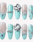 Flat lay of Aqua Bijou press-on nails with mint blue and ivory tones, pearl accents, and large crystal embellishments