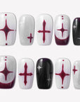 Blood Moon Cross press-on nails with black, white, silver glitter, and burgundy designs, featuring cross starburst accents, curved moon tips, and glossy square shapes