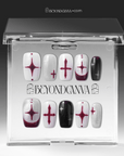 Packaging display of Blood Moon Cross press-on nails in a clear Beyondcanva case with black, white, silver glitter, and burgundy designs, cross starburst accents, and glossy square shapes