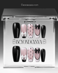 Packaging display of Chérie Noir press-on nails in a clear Beyondcanva case with glossy black nails, nude pink polka dots, black French outline, and raised bow designs