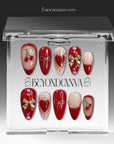Cherry Devotion press-on nail set displayed in clear packaging with red, blush, and gold cherry, bow, and heart accents