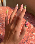 Lifestyle hand model photo of multicolor floral press-on nails in warm natural light.