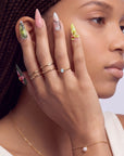 Profile of a model wearing multicolor floral press-on nails with pink, yellow, and green accents.