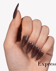 Hand model wearing Fall Essence Espresso press-on nails in a dark espresso brown shade with glossy almond-shaped tips