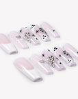 Angled flat lay of Ghosted Love press-on nails with pink translucent bases, white spider webs, ghost faces, silver rhinestones, and heart accents