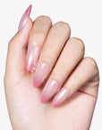 Hand model wearing Glazed French almond press-on nails with pearly nude bases and translucent pink French tips