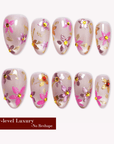 Golden Meadow pink floral cat-eye press-on nails arranged in a flat lay on a white background