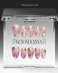 Pink floral cat-eye press-on nails displayed in packaging on a white background