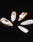 Detail flat lay of Golden Shell white and gold press-on nails with sculpted seashell and pearl accents