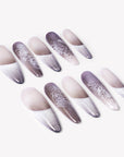 Angled flat lay of Himalayan Mist press-on nails with gray lilac mist gradient, white French tips, silver crackle lines, and lace-like texture