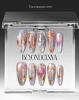 Iridescent pearl press-on nails displayed in clear packaging with silver, blush pink, and gold foil accents
