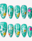 Island Lagoon handmade press-on nails in shimmering turquoise with tropical flower accents, arranged on a white background.