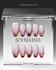 Jewel Sunset press-on nails displayed in clear packaging with soft pink bases, ruby red tips, and multicolor gem accents