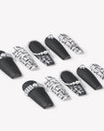 Angled flat lay of Lace & Pearls press-on nails with black matte tips, black and white lace pattern accents, and pearl embellishments