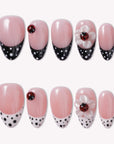 Ladybug Garden press-on nails with pink bases, black and white polka dot French tips, red ladybugs, and white flower charms