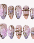 Lavender Lyric handmade press on nails in a white flat lay with lavender, blush pink, gold accents, and floral details