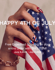 Patriotic hand model holding an American flag cloth with red, white, and blue press-on nails for a 4th of July promotion.