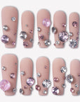 Luxurious Treasure press-on nails with nude pink square bases covered in large pink and clear rhinestone gems for a jeweled look