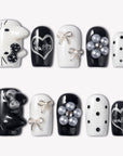 Monochrome Meow press-on nails with black and white cat designs, silver bow accents, pearl charms, polka dots, and happy heart lettering