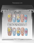 A set of beach-inspired press-on nails displayed in a clear BeyondCanva box package