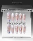 Opal Whisper press-on nails in pale pink and clear shimmer with white flower accents displayed in a clear packaging box