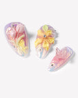 Close-up of Pastel Bloom pink and blue nails with sculpted tulips, yellow flowers and a clear butterfly charm