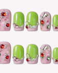 Pastel Dream handmade press-on nails in a flat lay with pink marble bases, lime green tips, and jeweled embellishments