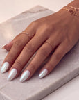 Pearl white iridescent press-on nails with subtle gemstone accents