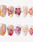 Petal Poem colorful press-on nails with raised purple, pink, peach and yellow flower designs in a white flat lay