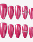 Flat lay of glossy hot pink press-on nails with a crystal accent on a white background.