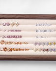 Display tray of precision-cut crystals in pink, clear, amber, and mixed shapes