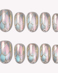 A set of iridescent pastel press-on nails with leaf-like metallic outlines on a white background