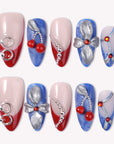 Rebel Cherry handmade press-on nails with red French tips, blue textured accents, silver bows, and cherry charms