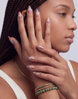 Profile portrait of a hand model wearing Rose Veil Aureate press-on nails in blush pink, ivory, and gold foil