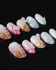 Flat lay of multicolor pearl-textured press-on nails with shell-like finish on a black background.