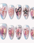 A set of iridescent blue and pink press-on nails with 3D bows, star accents, and rhinestone details on a white background