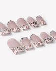 Flat lay of Sugar Kitten press-on nails with nude pink bases, leopard print French tips, and clear rhinestone accents