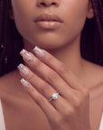Portrait hand model wearing Sugar Kitten press-on nails with nude pink bases, leopard French tips, and rhinestone details