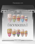 Sunset Gypsy handmade press-on nails displayed inside clear packaging with two sets of decorated nails on a white insert