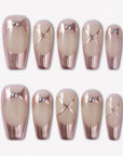 Swan Lake Dream press-on nails with rose gold metallic French tips, nude jelly bases, crisscross accents, and rhinestones