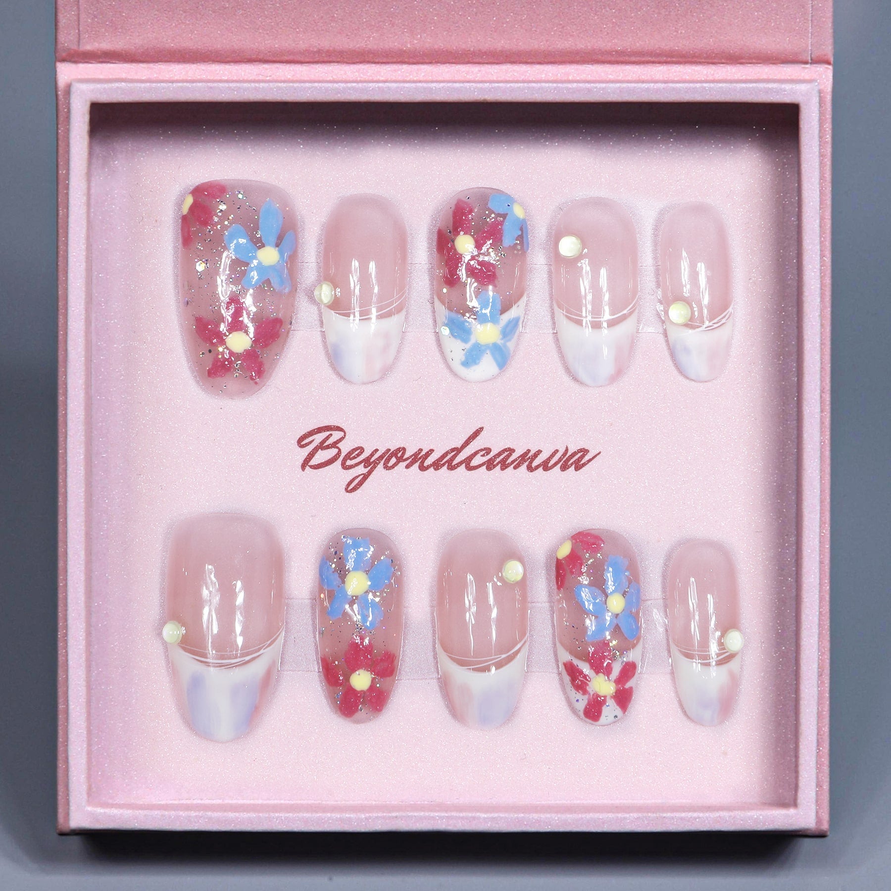 Beyondcanva press-on nails featuring colorful floral accents on a soft pink base, ideal for a chic and feminine style.