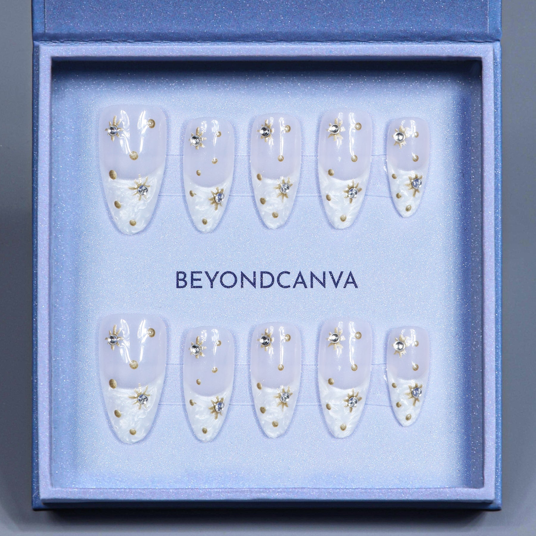 Elegant press-on nails by Beyondcanva, featuring clear almond shapes adorned with gold dots, delicate pearls, and sparkling rhinestones.