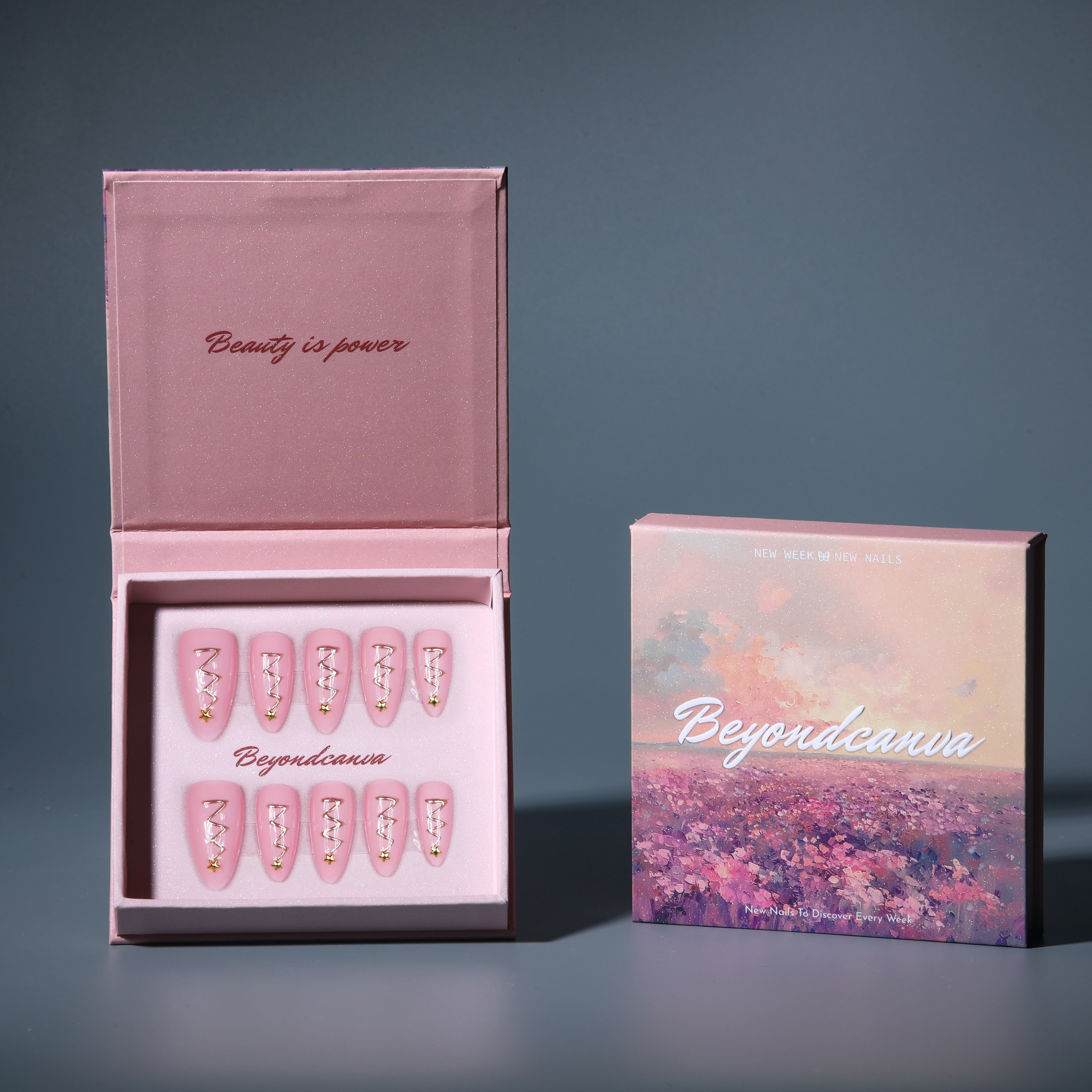 This beyondcanva press-on nail set features pastel pink nails with festive gold zigzag accents and star embellishments, resembling Christmas trees. Packaged in a luxurious pink box, it’s perfect for a chic holiday look.