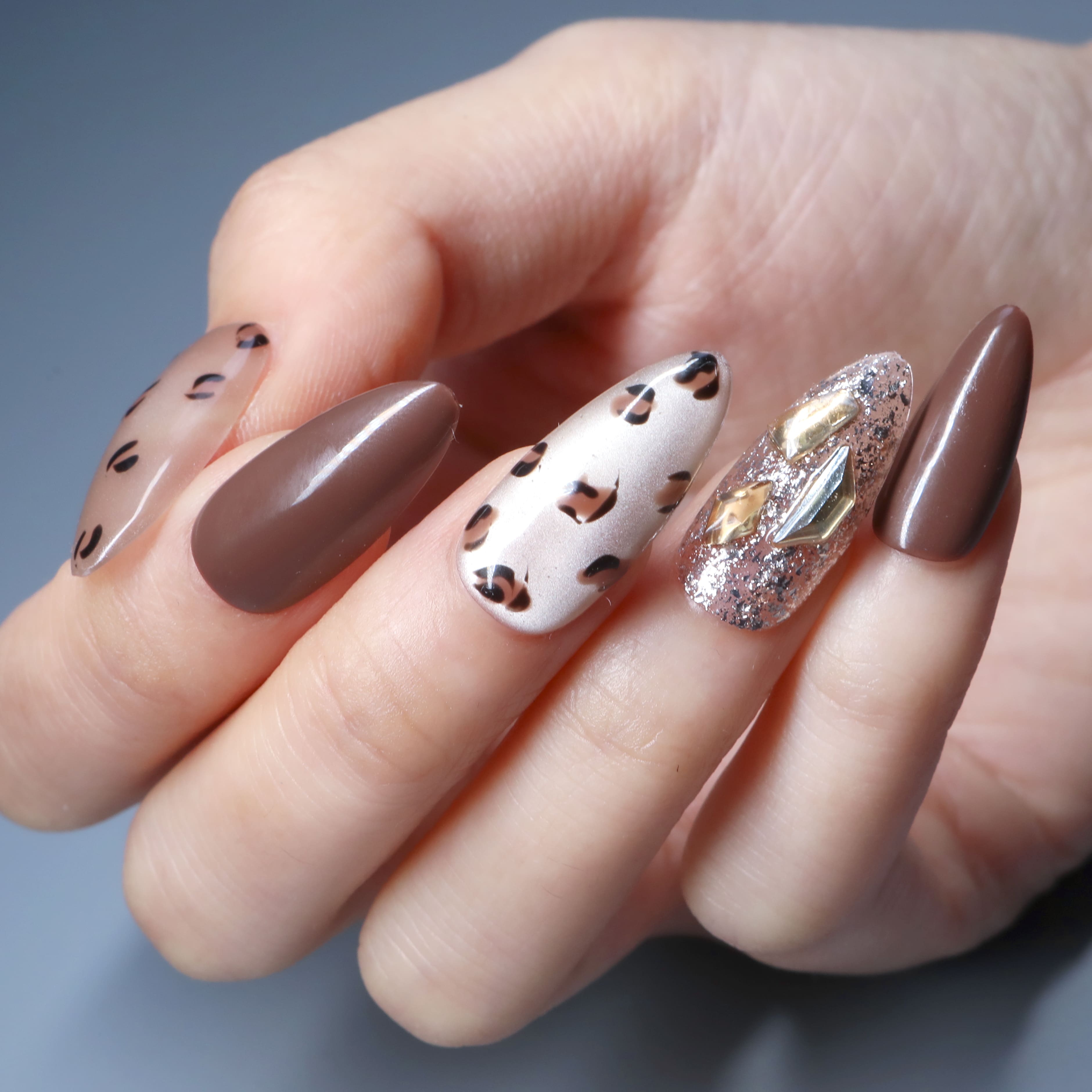 Leopard Glitz press-on nails by BEYONDCANVA, featuring leopard print, gold accents, cat-eye design, and gemstone details for a bold look.