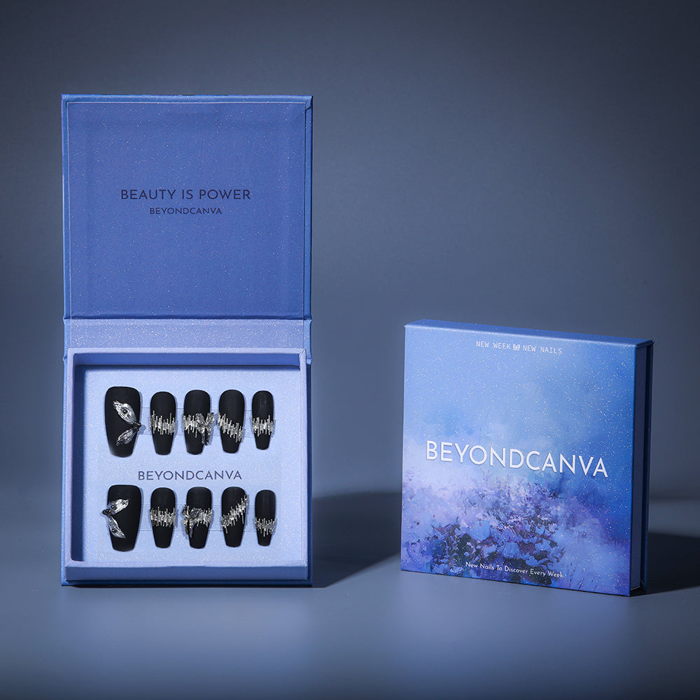 BEYONDCANVA luxury press-on nails set in matte black, embellished with intricate silver accents and 3D details, elegantly packaged in a blue box.