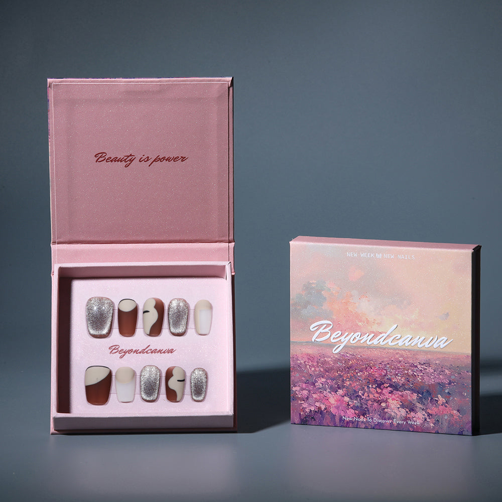 BEYONDCANVA press-on nails set showcasing individual nails with matte brown, cream, and glitter designs, captured on a reflective surface.