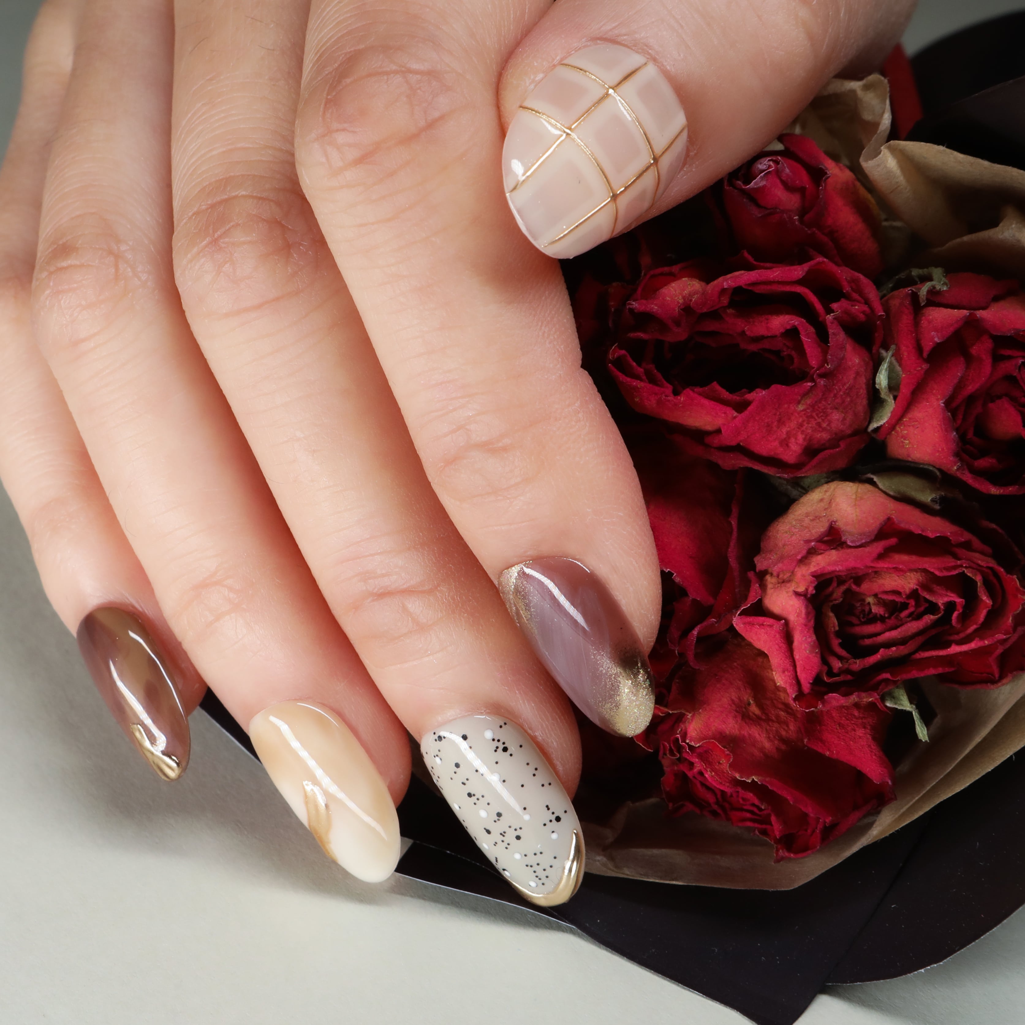 beyondcanva elegant press-on nails with brown tones, gold accents, grid patterns, and marble-inspired designs.