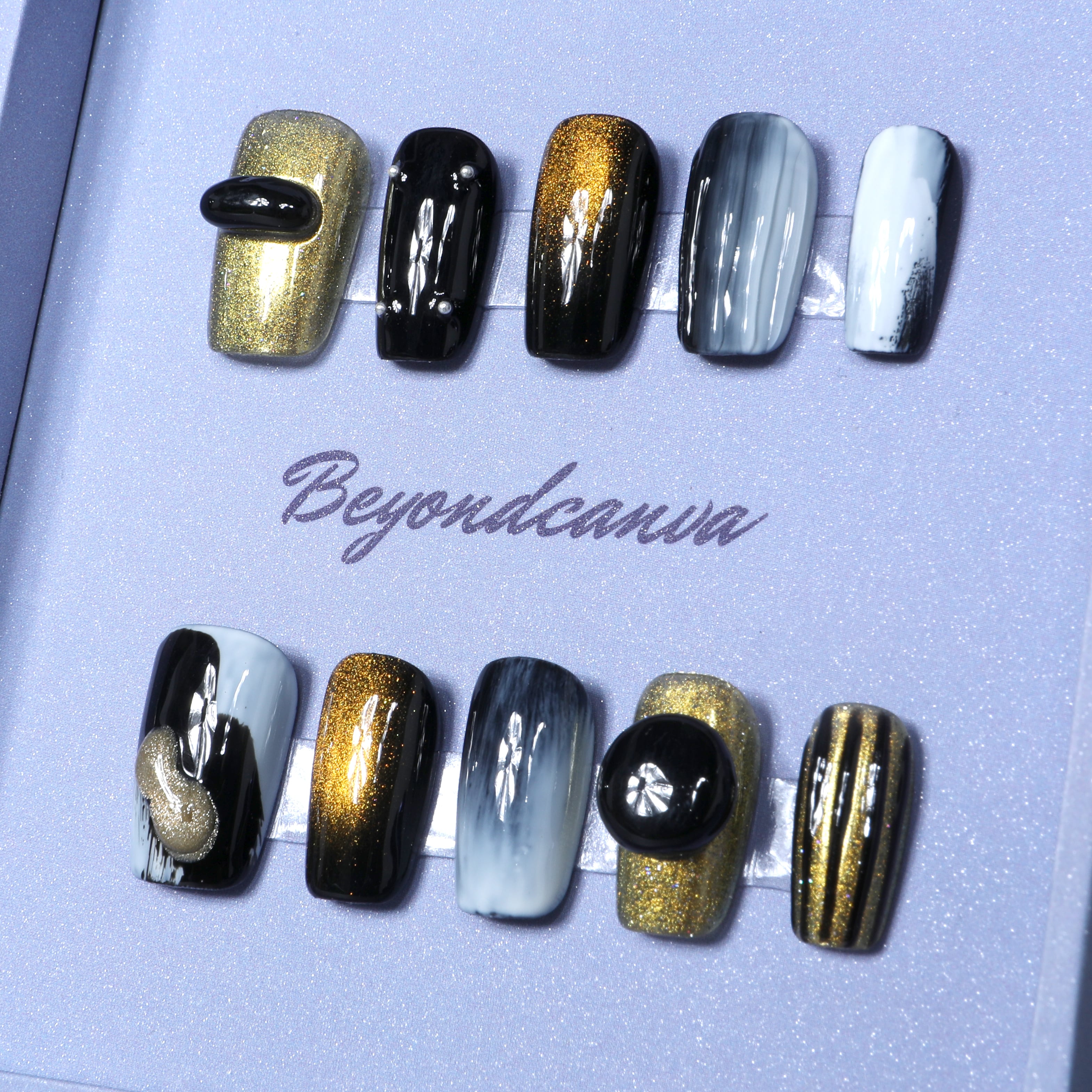 This beyondcanva press-on nail set features bold black, gold, and white tones with shimmering accents for a luxurious statement.